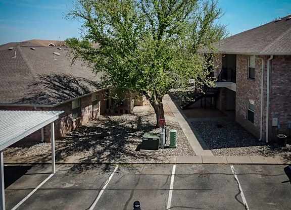 A tree in a courtyard surrounded by buildings.