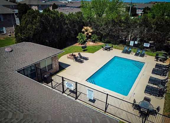A pool surrounded by a black fence and a sign on the fence.