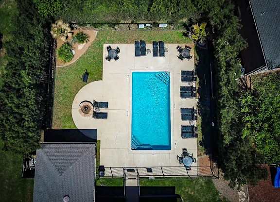 An aerial view of a backyard with a swimming pool and patio furniture.