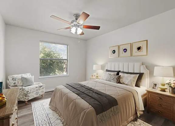 A bedroom with a large bed and a ceiling fan.