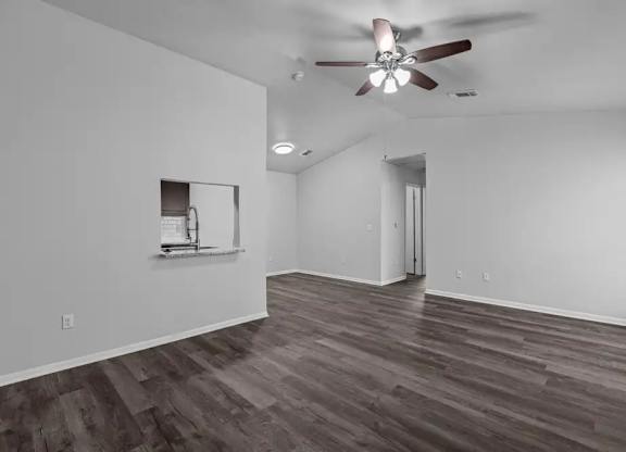 A room with a ceiling fan and a mirror on the wall.