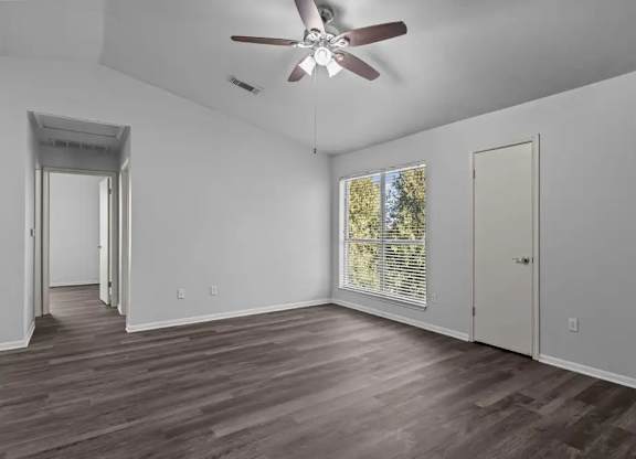 A room with a ceiling fan and wooden flooring.