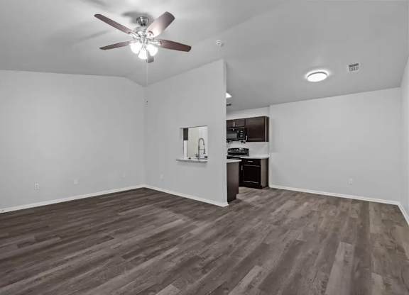 A room with a ceiling fan and wooden flooring.