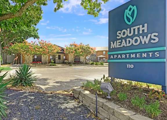 Monument sign with landscaped entrance garden at South Meadows Apartments, Red Oak, TX 75154
