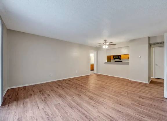 Spacious living room with wood style flooring at South Meadows Apartments, Red Oak, Texas