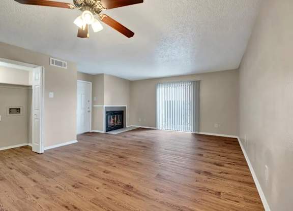 Empty living room with fireplace and vaulted ceiling at South Meadows Apartments, Texas, 75154