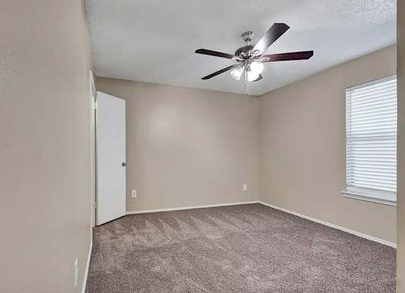 Empty bedroom with carpet and ceiling fan at South Meadows Apartments, Texas, 75154