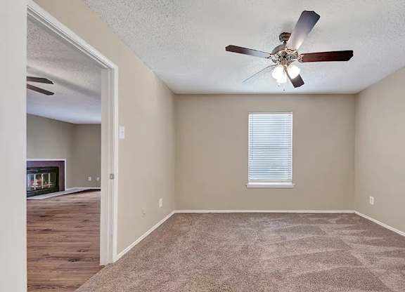 Carpeted bedroom with window blinds and ceiling fan at South Meadows Apartments, Red Oak, TX 75154