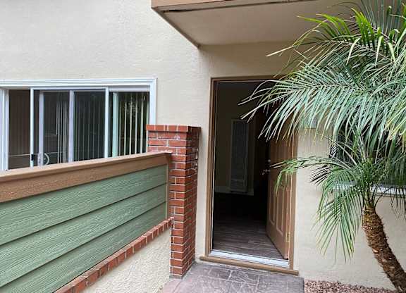 a entryway to an apartment with a palm tree