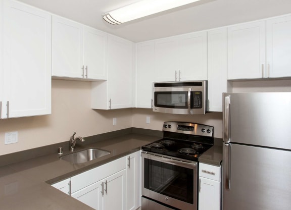 a kitchen with white cabinets and stainless steel appliances