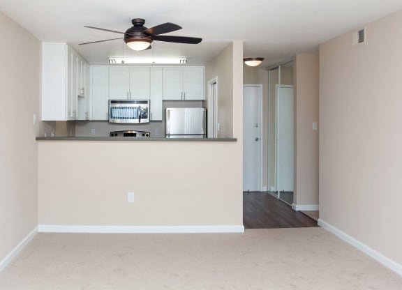 a bedroom with a large window and a ceiling fan