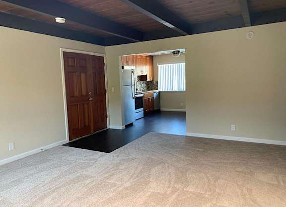 a empty living room with a kitchen in it