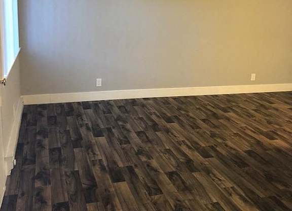 A room with a wooden floor and a white door.