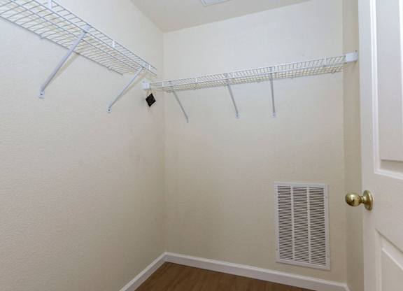 A white closet with a door and a vent.