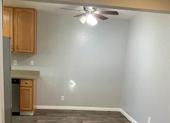 A room with wooden flooring and a ceiling fan.