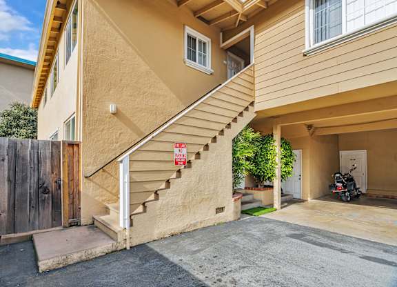 A tan building with a staircase leading to the second floor.