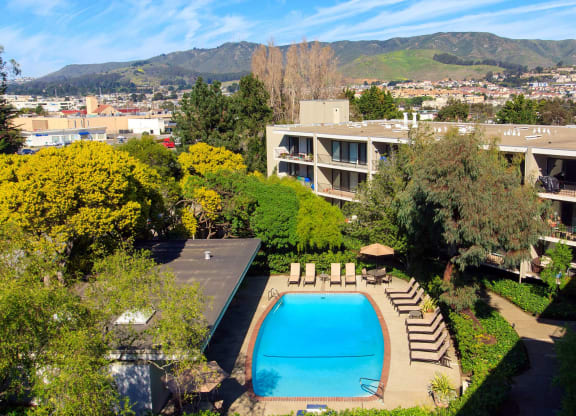 an aerial view of a swimming pool with a hotel in the background