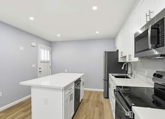 A kitchen with a white countertop and black appliances.
