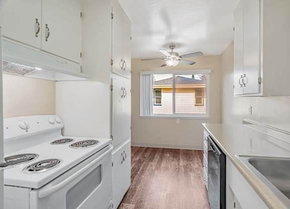 A kitchen with white appliances and cabinets.