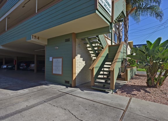 A green building with a staircase leading to the entrance.