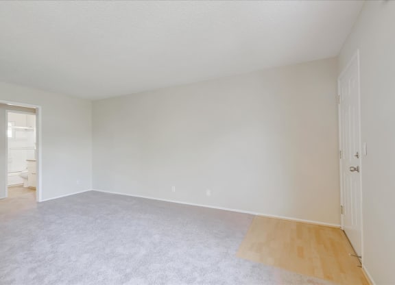 an empty living room with white walls and a hard wood floor
