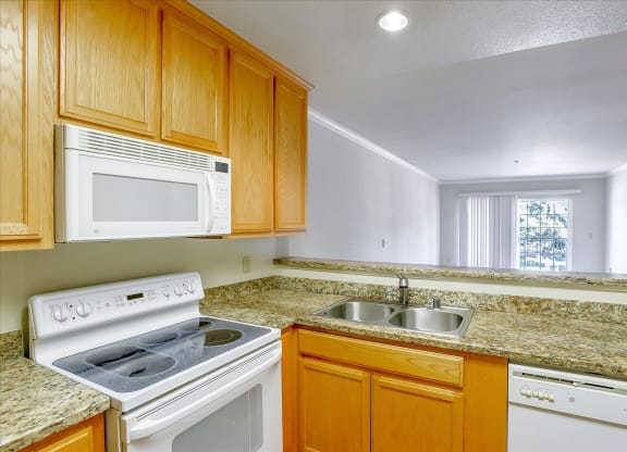 A kitchen with wooden cabinets and granite countertops.