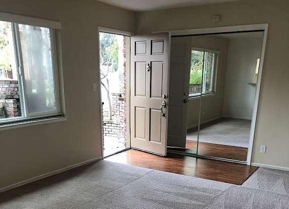 A room with a grey carpet and a white door.