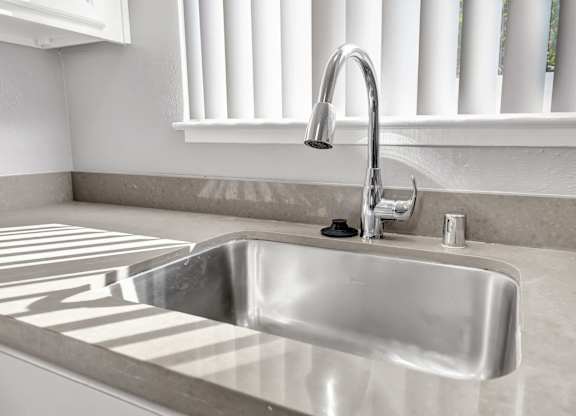 A modern kitchen sink with a chrome faucet.