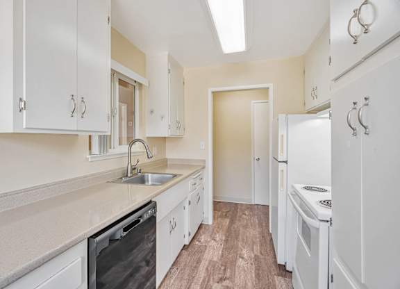 A kitchen with white cabinets and appliances.