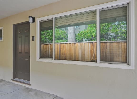 A brown wooden fence is seen through a window.
