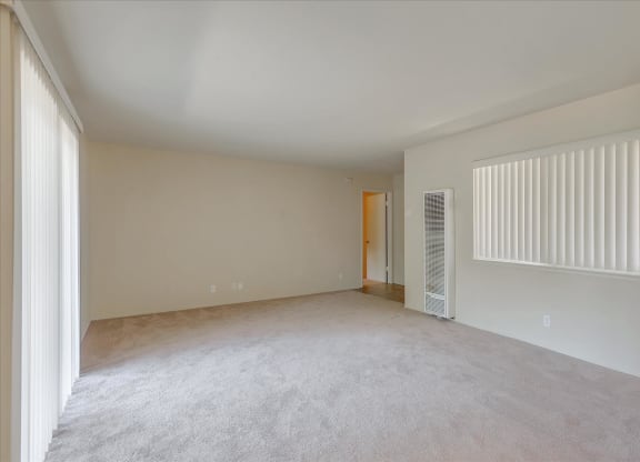 Empty room with carpeted floor and white walls.