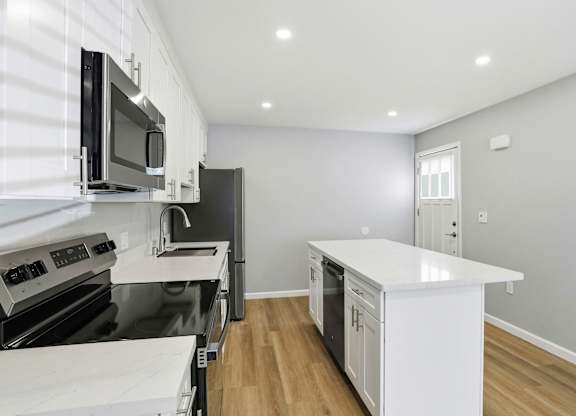 A modern kitchen with white appliances and a large island.