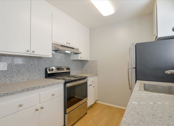 a kitchen with white cabinets and a stove and a refrigerator