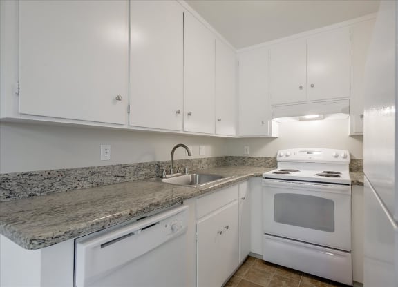 a kitchen with white appliances and granite counter tops