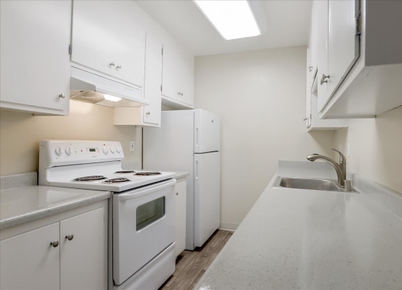 a white kitchen with white appliances and white cabinets