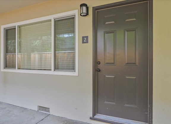 A brown door with a number 2 on the wall above it.