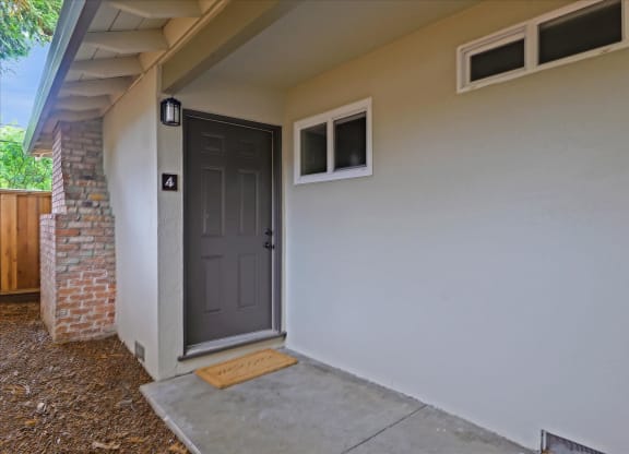 An apartment with a grey door and a small window above it.