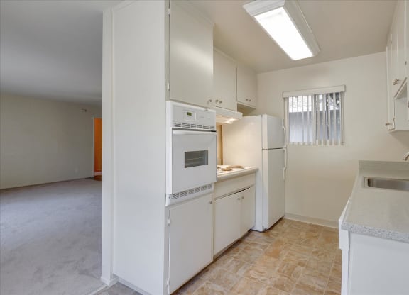 A kitchen with white appliances and cabinets.