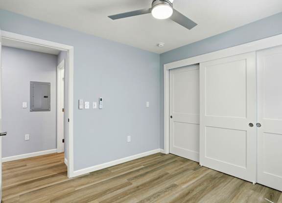 A room with a ceiling fan and two doors.