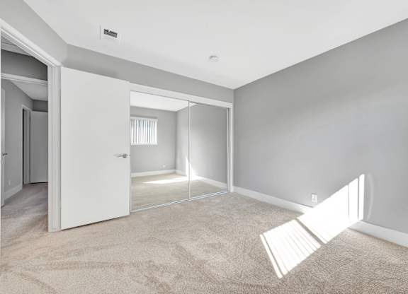 A room with a white door and a carpeted floor.