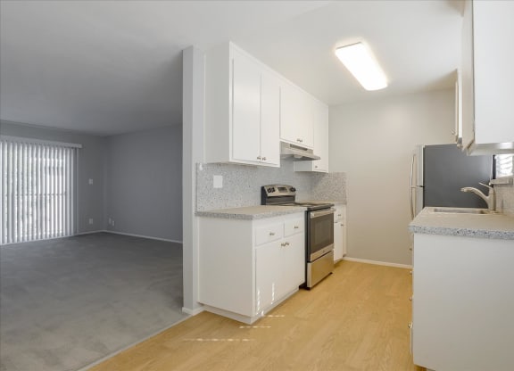a kitchen with white cabinets and a stove and a refrigerator