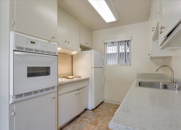 A kitchen with white appliances and cabinets.