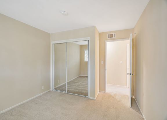 A room with a carpeted floor and a sliding glass door.