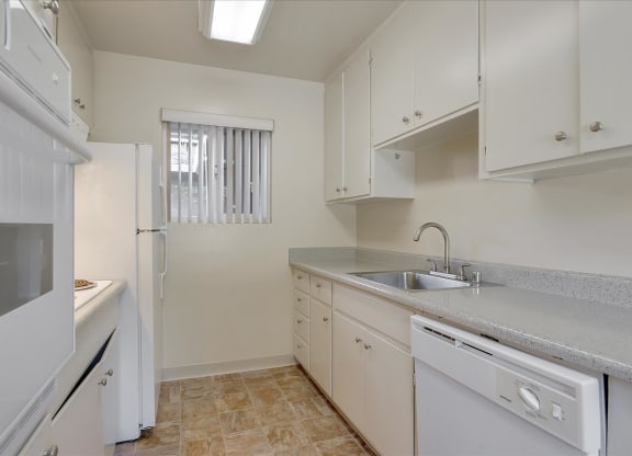 A kitchen with white appliances and cabinets.