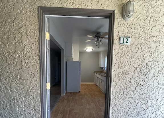 a door is open to a room with a refrigerator