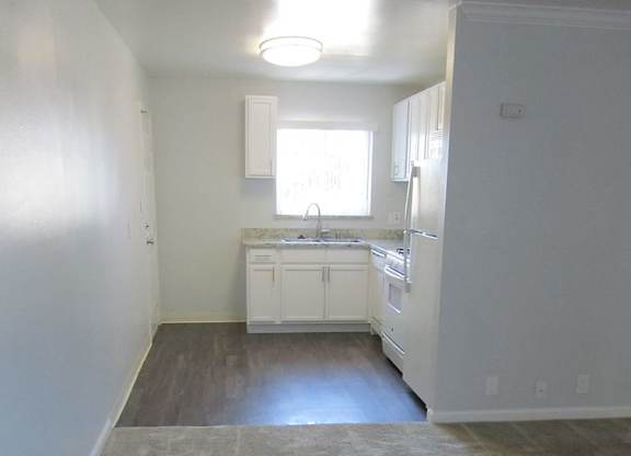 A kitchen with white cabinets and a sink.