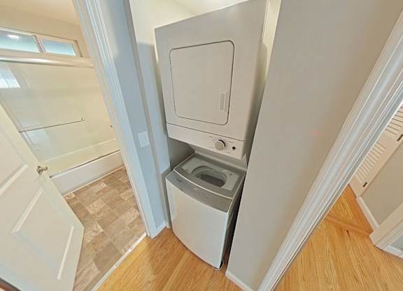 A white washing machine is in a small laundry room.