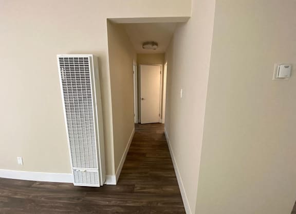 an empty hallway with a heater on the wall