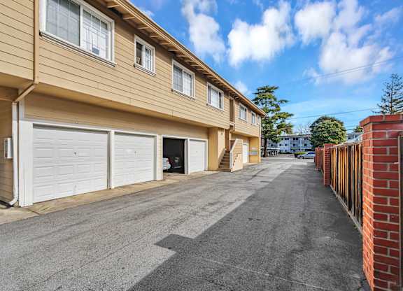 A row of houses with garages and driveways.