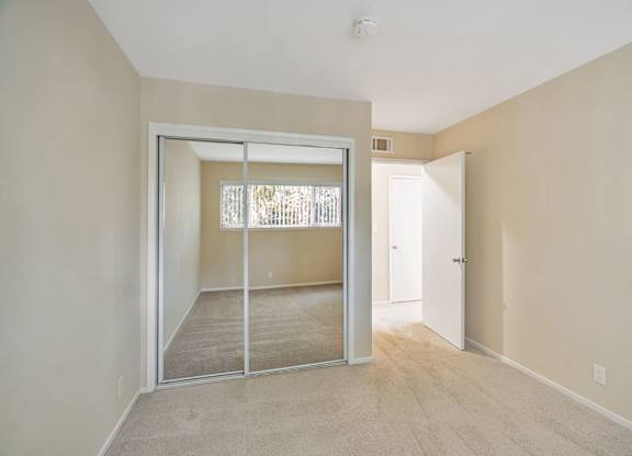 A room with a sliding glass door leading to a balcony.